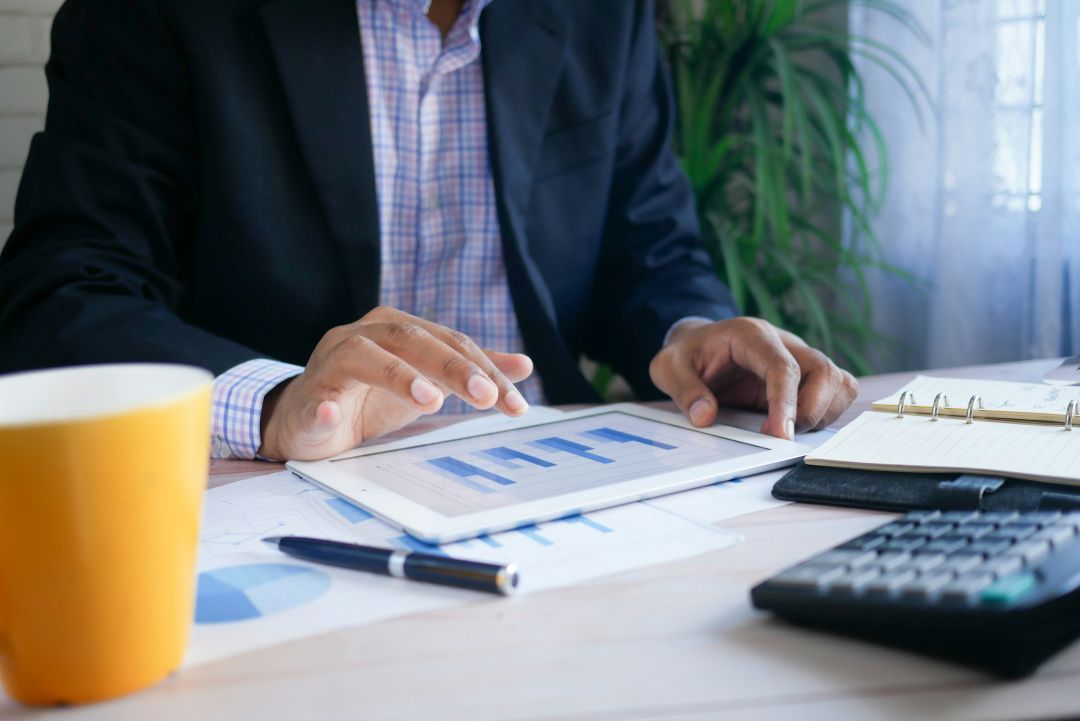 Geschäftsperson analysiert Finanzdaten auf einem Tablet für professionelles Forderungsmanagement.