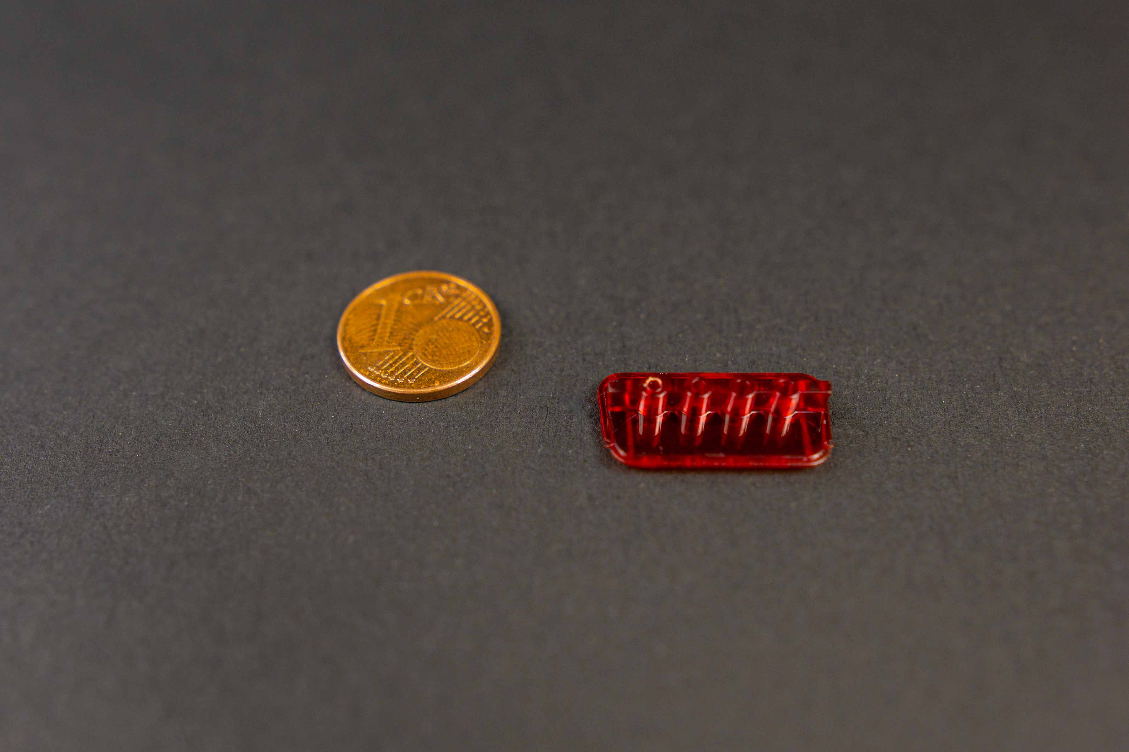 Mikrospritzgussteil aus transparentem Kunststoff im Größenvergleich mit einer 1-Cent-Münze – gefertigt bei Speedpart